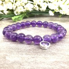 ✦Gemstone: Natural Amethyst ✦Material: Sterling Silver CZ Charm ✦Color: Purple ✦Shape: Round  ✦Length: 5''-9'' ✦Bead Size: 8mm  ✦QTY: 1 pcs / package ✦The 8mm bracelet comes with 8mm sterling silver CZ charm ✦✦Please measure your wrist size, then order your bracelet. This bracelet makes the perfect gift for just about anyone in your friend or family circle. We have over 12 unique gemstone options to choose from. Please visit our store for more birthstones selection.  Amethyst carries a calming and serene energy that will help you unwind and relax. It soothes the body, reducing anxious nerves and restlessness. Amethyst is an excellent crystal to use when you feel jittery or wound up. It will ease your muscles and instantly help you feel more relaxed and peaceful. You will receive the same q Purple Amethyst Round Beads Crystal Bracelet, Adjustable Purple Crystal Bracelet Hand-strung, Hand-strung Purple Crystal Round Bracelet, Hand-strung Lavender Amethyst Beaded Bracelets, Adjustable Nickel-free Amethyst Bracelets, Amethyst Bracelet Beads, Amethyst Bracelet, Amethyst Beads, Elastic Bracelet