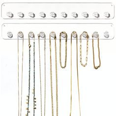 a bunch of necklaces hanging on a white wall with hooks and chains attached to it