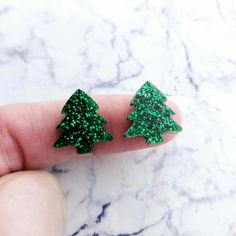 16mm Laser Cut GREEN GLITTER Acrylic Christmas Trees. Size: 16mm high x 14.8mm wide Thickness: 3mm These gorgeous Green Glitter Christmas trees make the perfect Xmas studs. **Please note, these items have a protective coating that is used to protect the acrylic during cutting and transit to you. **We strive to display product colours as accurately as possible, however images are intended as a guide only. Glitter Acrylic, Glitter Acrylics, Glitter Christmas, Green Glitter, Christmas Trees, Gift Baskets, Halloween Shopping, Laser Cut, Accessory Gift