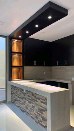 an empty kitchen with black cabinets and white counter tops