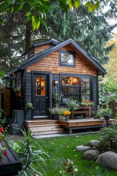 a small house with lots of plants in the yard