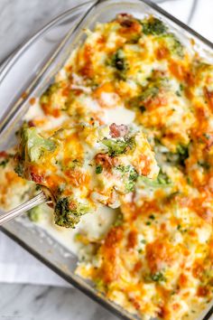 a casserole dish with broccoli, cheese and other vegetables in it