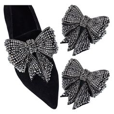 two pairs of black shoes with bows on the heel and one pair of crystal stones