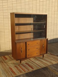 a wooden cabinet sitting on top of a rug