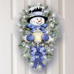 a christmas wreath with a snowman holding a lantern on the front door for $ 59 99