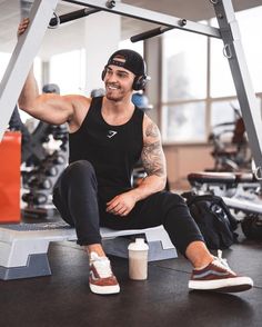 a man sitting on top of a bench in a gym