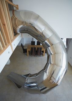 a large metal object sitting on top of a tiled floor next to a dining room table