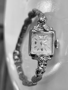 Vintage Art Deco 14k White Gold Hamilton Watch with genuine diamond accents. The watch is 14k gold with diamonds.  There are two larger round brilliant diamonds that measure 3.5mm in diameter and four smaller diamonds that are 1.5mm in diameter.  Total carat weight of the diamonds is approximately 0.42 calculated by measurements.  They are round brilliant cut and nice quality in the range of SI1 clarity and H/I color.   The watch face and bezel are solid 14k white gold and stamped.  The band is Classic Diamond White Round Diamond Watch, Yellow Gold Watches With Diamond Accents For Gift, Yellow Gold Watches With Diamond Accents As Gift, Classic Diamond Jewelry With Brilliant Cut, Classic Diamond Accented Watch For Anniversary, Formal Yellow Gold Diamond Watch With Diamond Accents, Yellow Gold Diamond Watch With Brilliant Cut For Anniversary, Formal Yellow Gold Diamond Watch With Accents, Anniversary Diamond Watch In Yellow Gold