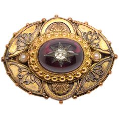 14-carat gold clasp with garnet and diamond. 14-carat gold-plated oval brooch finished with a gold-plated beaded cord adorned at the front with a curved composition that leaves smooth spaces for simplified plant motifs and two semicircles on the vertical axis of the smaller side which cover other plant elements. In the center, framed by a band with strings and pearls in gold and with two small pearls on the major axis (in the triangular spaces that leave the curves already mentioned), is placed Ceremonial Gold Brooches With 17 Jewels, Victorian Oval Jewelry For Opera, Luxury Oval Cabochon Brooches, Formal Jeweled Yellow Gold Jewelry, Formal Medallion Brooch Jewelry, Formal Yellow Gold Jeweled Jewelry, Antique Oval Brooch Jewelry, Luxury Oval Jewelry For Opera, Antique Oval Cabochon Brooch For Formal Occasions