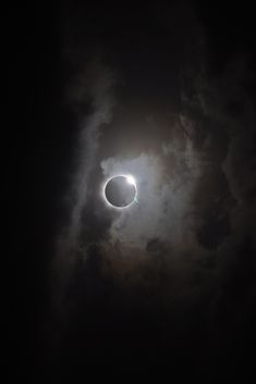 the solar eclipse seen through clouds during a dark night