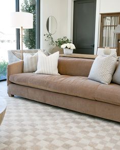 a living room filled with furniture and a large mirror on the wall next to a window