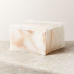 a white marble block sitting on top of a table next to a wall and floor