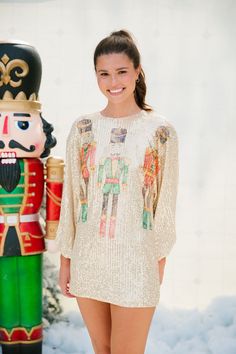 Introducing our NUTCRACKER LONG-SLEEVE GOLD SEQUIN DRESS, the perfect addition to your holiday wardrobe. This stunning long-sleeve dress features a gorgeous gold sequin design that is sure to catch everyone's eye. The cinched wrists add a touch of elegance while the nutcracker trio print adds a playful twist. 'Tis the season to shine! All orders are currently shipping within 14 business days. To receive item quicker, expedited shipping is available at checkout. **All Christmas orders must be pla Gold Long Sleeve Festive Dress, Festive Gold Long Sleeve Dress, Holiday Gold Embellished Sequin Dress, Festive Gold Long Sleeve Sequin Dress, Holiday Gold Fitted Sequin Fabric, Gold Sequin Top, Holiday Soiree, Gold Sequin Dress, Gold Sequin