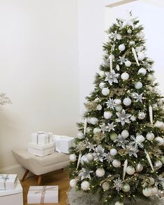 a decorated christmas tree with white and silver ornaments