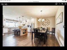 an image of a kitchen and dining room in the same house, with one large clock on the wall