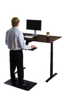 a person standing at a desk with a computer on it