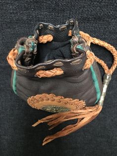 a brown and green purse sitting on top of a black floor next to a wall