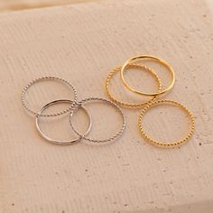 Our Skinny Stacking Rings are the simple and minimalist essentials for creating a dainty, multilayered finger stack that'll be the envy everyone around you. Their slightly textured finish adds a unique touch to the stack, as the trio features a ball, twist, and smooth band. Material: High-Quality Solid 925 Sterling Silver Finish: Sterling Silver ∙ 18K Gold Dimensions: 1mm This listing is for a set of 3 rings: 1 SOLID ring, 1 TWISTED ring, and 1 BEADED ring SKU: RR-RR051 Sizing Guide Rings are cr Trendy Tarnish-resistant Stackable Rings, Minimalist Stacked Midi Rings As Gift, Dainty Stackable Rings With Metal Round Band, Minimalist Stackable Double Band Midi Rings, Minimalist Double Band Stackable Rings, Minimalist Stacked Midi Rings For Promise, Minimalist Stackable Rings, Stacked Minimalist Midi Rings, Trendy Tarnish Resistant Stackable Rings