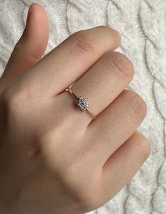 a woman's hand with a diamond ring on it