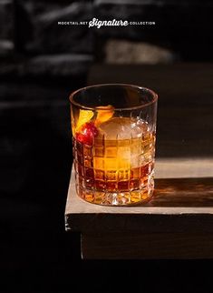 a glass filled with liquid sitting on top of a wooden table