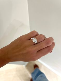 a person's hand holding an engagement ring