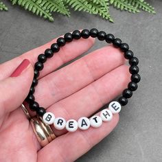 BREATHE Acrylic Bead Bracelet - the perfect mix of style and motivation, this bracelet features a simple yet inspiring design to remind you to take a moment to breathe. Available in a variety of colors, choose the one that speaks to you. The custom made bracelet has 6mm acrylic beads and flat white acrylic letter beads, which are 7mm diameter. It is thread on strong elastic and will stretch a little bit so you can roll it onto your wrist gently. Allergy friendly, lightweight and super comfortable to wear! Comes in more than 20 gorgeous colour options and 12 sizes up to 4XL, so you will always find one that fits! Holistic Stretch Bracelet With Round Beads For Everyday, Casual Personalized Beaded Bracelets For Everyday, Personalized Casual Stretch Bracelet For Everyday, Casual Personalized Stretch Bracelet For Everyday, Casual Black Friendship Bracelets With 8mm Beads, Inspirational Beaded Bracelets For Everyday, Inspirational Adjustable Hypoallergenic Beaded Bracelets, Casual Hypoallergenic Beaded Bracelet For Everyday, Adjustable Inspirational Bracelets With 8mm Beads