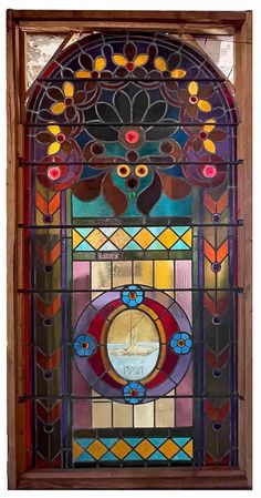 an ornate stained glass window with flowers and leaves on it's sides, in the shape of a circle