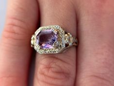 Size 5 1/2 with a 1.7 carat amethyst. Step into timeless elegance with this exquisite Vintage Filigree Amethyst Ring in 14K white gold. Crafted in an era where craftsmanship met artistry, this ring features a stunning unique cut amethyst that radiates a deep, captivating purple hue, perfectly complemented by intricate filigree detailing along the band. The 14K white gold setting not only enhances the rich color of the gemstone but also adds a touch of luxury and durability to this heirloom piece. Whether you're adding to your vintage jewelry collection or seeking a unique statement piece, this ring is sure to evoke admiration and envy alike. Don't miss the chance to own a piece of history and make it your own today. Elegant Lavender Amethyst Ring In 14k Gold, Elegant Amethyst Wedding Ring, Elegant Wedding Amethyst Ring, Exquisite Yellow Gold Amethyst Ring With Accent Stones, Elegant Emerald Cut Amethyst Ring, Heirloom Amethyst Ring With Accent Stones, Heirloom Amethyst Ring With Center Stone, Lavender Amethyst Ring For Formal Occasions, Elegant Amethyst Ring With Diamond Cut For Anniversary