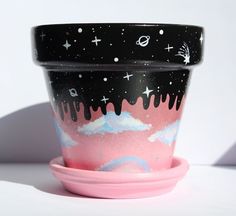 a pink and black cup sitting on top of a saucer next to a white wall