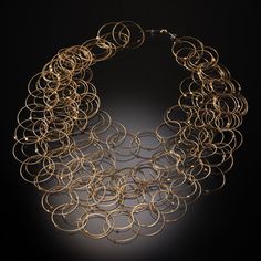 Gold & Steel Necklace - Hand-formed rings of 14k gold-plated stainless steel cable create a tumbling cascade of interconnected links on this lightweight necklace. The overlapping circles create a unique pattern reminiscent of Venn diagrams. Neodymium magnet clasp. Modern Multi-strand Gold Jewelry, Modern Gold Multi-strand Jewelry, Modern Gold Spiral Jewelry, Modern Multi-strand Chain Jewelry, Venn Diagrams, Overlapping Circles, Creative Necklace, Stainless Steel Cable, Bronze Gold