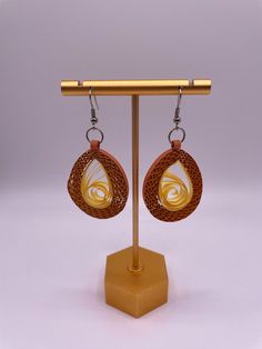 a pair of earrings is shown on a stand