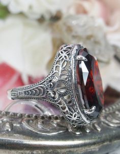 Red Garnet Ring Description Persian Design#230 MADE TO ORDER This is a brand new stunning Art Nouveau/Vintage designed sterling silver filigree 9ct oval red garnet CZ ring. The Flawless oval full cut high-quality garnet CZ is 18mm (just shy of 3/4th of an inch) by 13mm (1/2 inch) in dimension... This ring is 21mm NS on the finger. The inside of the band is marked 925 for sterling. Notice the beautiful filigree swirl like the craftsmanship of the silver setting. This lovely ring stands out and il Classic Oval Ruby Ring, Victorian Red Oval Filigree Ring, Vintage Garnet Ruby Ring With Intricate Design, Vintage Ruby Ring With Intricate Design, Antique Style Oval Filigree Ring With Center Stone, Antique Oval Filigree Ring With Center Stone, Vintage Garnet Ring With Center Stone, Antique Oval Filigree Ring Gift, Antique Red Oval Filigree Ring