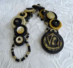 Stacked black and tan vintage and antique buttons create this beautiful bracelet for Fall. Large button with the beaded loop serves as a secure clasp. Constructed with needle and strong beading thread. One of a kind. Made in Maine. Vintage Black Beaded Bracelets, Vintage Black Round Bead Bracelets, Handmade Vintage Beaded Bracelets, Recycled Bracelets, Cuff Bracelets Handmade, Button Bracelet, Large Buttons, Antique Buttons, Button Jewelry