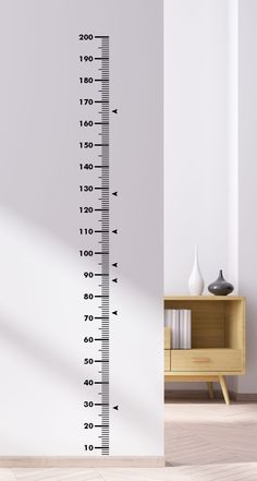 a tall growth chart wall decal in a room with white walls and wooden flooring