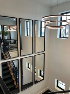 a staircase with mirrors on the wall and stairs leading up to it's second floor