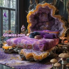 a bed made out of rocks with purple and yellow colors on it, in front of a large window