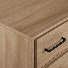 a close up of a wooden drawer with black handles