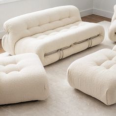 a living room filled with white furniture on top of a hard wood floored floor