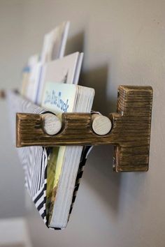 a wooden shelf with some books on it and two magnets attached to the wall