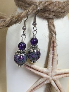 Life is short - wear pretty things! A beautiful pair of purple & olive speckled dangle earrings that will be a great wardrobe accessory. Also a great gift idea. Earrings are made using surgical steel ear wires. I use wrapped loops to give the earring a more finished look. Earrings come with rubber ear backs that slide on to keep earrings from falling out of ears. Color: dark purple, olive green, Deep purple pearl, Earrings length: 1 3/4 inches YOU MAY ALSO LIKE: https://www.etsy.com/shop/Jil Bead Knit, Handmade Birthday Gifts, Birthday Gift For Mom, Wardrobe Accessories, Purple Pearl, Electronic Gifts, Beaded Dangle Earrings, Slide On, Wire Earrings