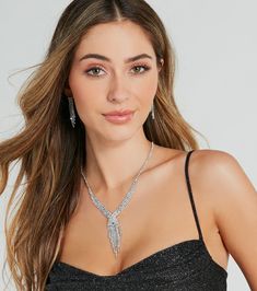 Dare to dazzle at your black-tie affair in this gorgeous rhinestone fringe necklace and earrings set! It features a V-shaped collar necklace with a single strand of rhinestones leading to a multi-row rhinestone design. The center features a cross-over detail and cascading asymmetric fringe for a chic allure. The matching short duster earrings feature a four-row asymmetric rhinestone fringe design for a seamless look. Style this set with a floor-sweeping formal dress﻿ and strappy stilettos.Fit & FeaturesNecklace and earrings setV-shaped collar necklace, back adjustable chain with lobster clasp closureSingle row of rhinestones, multi-row rhinestone designCenter cross-over detail with asymmetric fringeShort duster earrings, post back closures, rubber stoppersFour-row asymmetric rhinestone Elegant Rhinestone Jewelry Sets For Party, Elegant Evening Jewelry Sets With Rhinestones, Glamorous Crystal Rhinestone Dangle Necklace, Elegant Sparkling Rhinestone Necklace For Party, Glamorous Crystal Jewelry Sets With Rhinestones, Silver Glamorous Jewelry Sets For Evening, Glamorous Silver Jewelry Sets For Evening, Elegant Sparkling Jewelry Sets For Party, Glamorous Formal Jewelry Sets