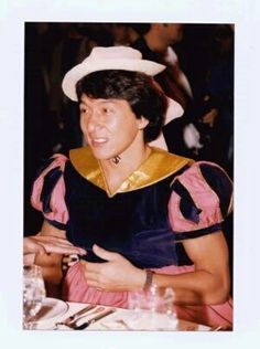 an old photo of a man wearing a sailor's outfit at a dinner table