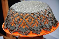 an orange and gray hat with crochet on it