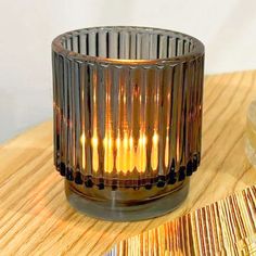 a small glass candle holder sitting on top of a wooden table