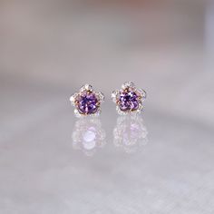 "These stylish earrings have a stunning bright color and the Amethyst is surrounded by a flower shape of shimmering diamonds. Perfect as a gift for her. Features * Made to Order. * Metal: 925 Sterling Silver * Custom Color: Rose Gold, Gold, Silver * Main Stone: Amethyst, 4mm dia Round Shape, 2pcs * Side Stone: Cubic Zirconia * Flower Measurements: around 6.64*6.60 mm Matching Amethyst Ring: https://etsy.me/32Rg6m4 Be sure to hit \"favorite\" on the right so it remains in your favorites list and/ Flower Shaped Earrings With Sparkling Stones For Gift, Amethyst Gemstone Earrings For Wedding, Amethyst Earrings With Gemstone Accents For Wedding, Wedding Earrings With Amethyst And Gemstone Accents, Purple Wedding Earrings With Prong Setting, Amethyst Gemstone Wedding Earrings, Wedding Amethyst Earrings With Gemstone Accents, Purple Gemstone Accent Earrings For Anniversary, Purple Drop Earrings For Anniversary