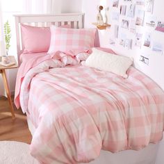 a bed with pink and white plaid sheets