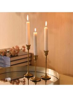 three candles sitting on top of a glass table