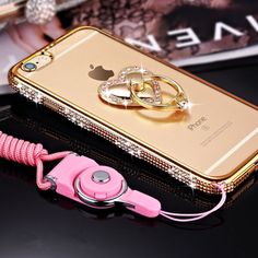 a phone with a pink cord attached to it and two gold rings on the back