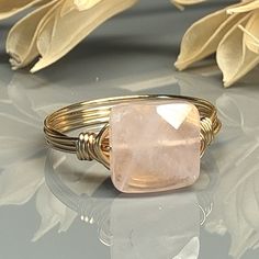 "Handmade Square Rose Quartz Gemstone and Sterling Silver, Yellow or Rose Gold Filled Wire Wrapped Ring; Custom Made to Size Experience the beauty and elegance of this stunning Rose Quartz Ring. This ring features a square gemstone that has been skillfully wire-wrapped in your choice of wire metal type for the band. The gemstone is custom made in multiple sizes, from 4 to 14, so you can find the perfect fit for your finger. The warm hues of the Rose Quartz gemstone are perfectly complemented by Adjustable Rose Quartz Jewelry In Rose Color, Adjustable Rose Quartz Rose-colored Jewelry, Adjustable Rose Quartz Rose Gold Ring, Handmade Adjustable Rose Quartz Rings, Handmade Adjustable Pink Crystal Ring, Wire Wrapped Rose, Ring Square, Rose Quartz Ring, Rose Quartz Gemstone