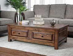 a wooden coffee table sitting on top of a rug in front of a gray couch